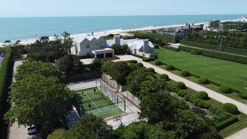 A padel court beside a beach house, seen from above