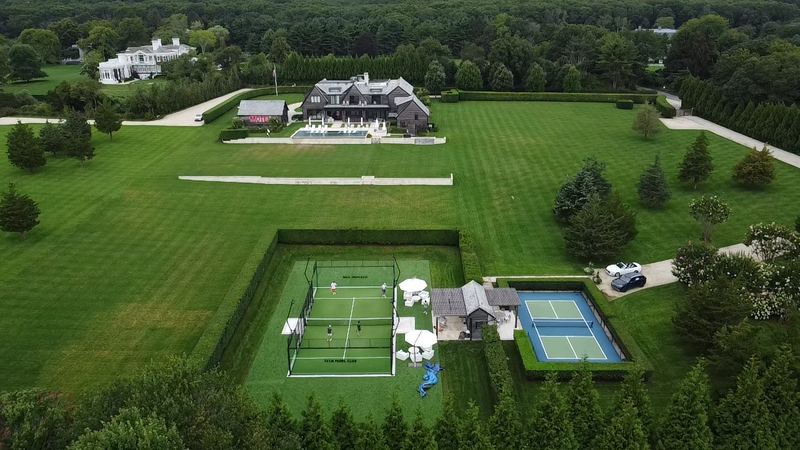 A padel court set in a wide lawn, seen from above
