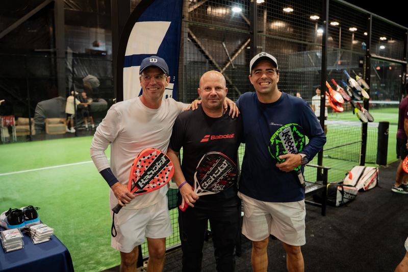 Three players with new racquets at a brand stand